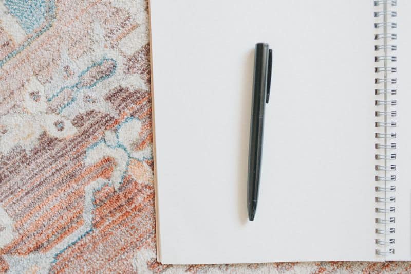 opened blank notepad with pen on top