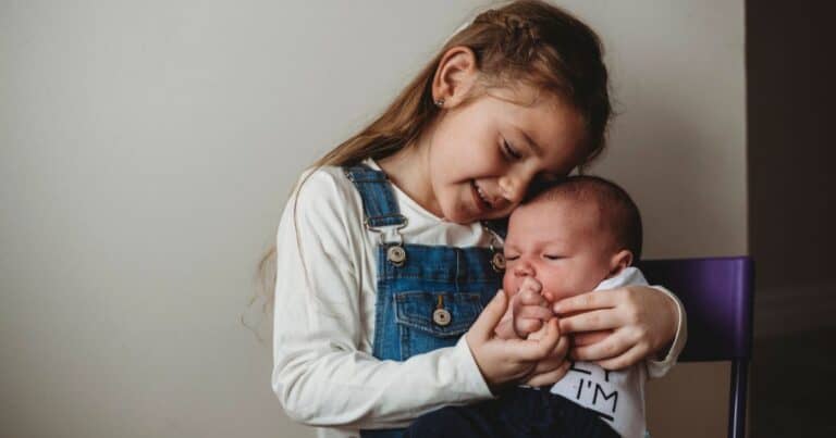 big sister holding baby