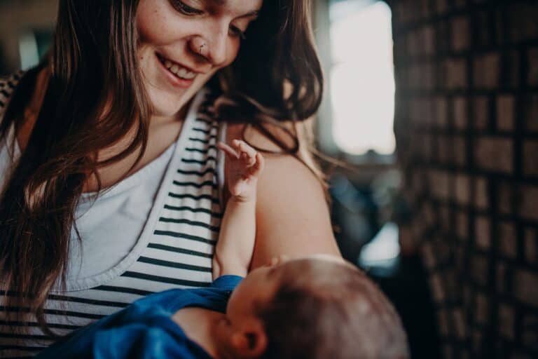 woman holding looking into baby's eyes while hold in arms